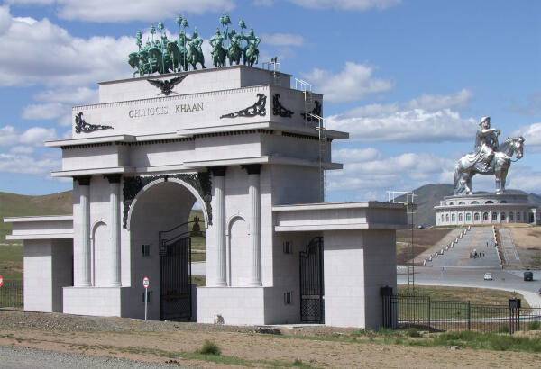 White entrance gate to the Chinggis Khaan Statue Complex, with the equestrian statue in the distance.