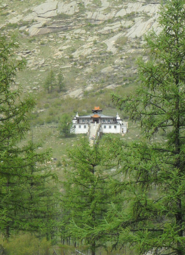 Ariyabal Meditation Temple, a white temple with a blue and gold roof, on a green hillside in Terelj National Park.